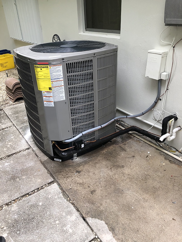 Heat pump installation Palm Beach County FL technician installing residential heat pump system